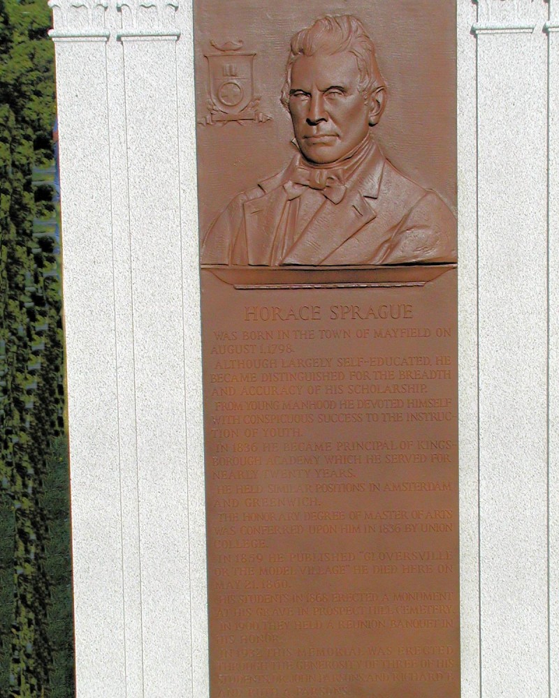 A plaque of an old man in front of a building.