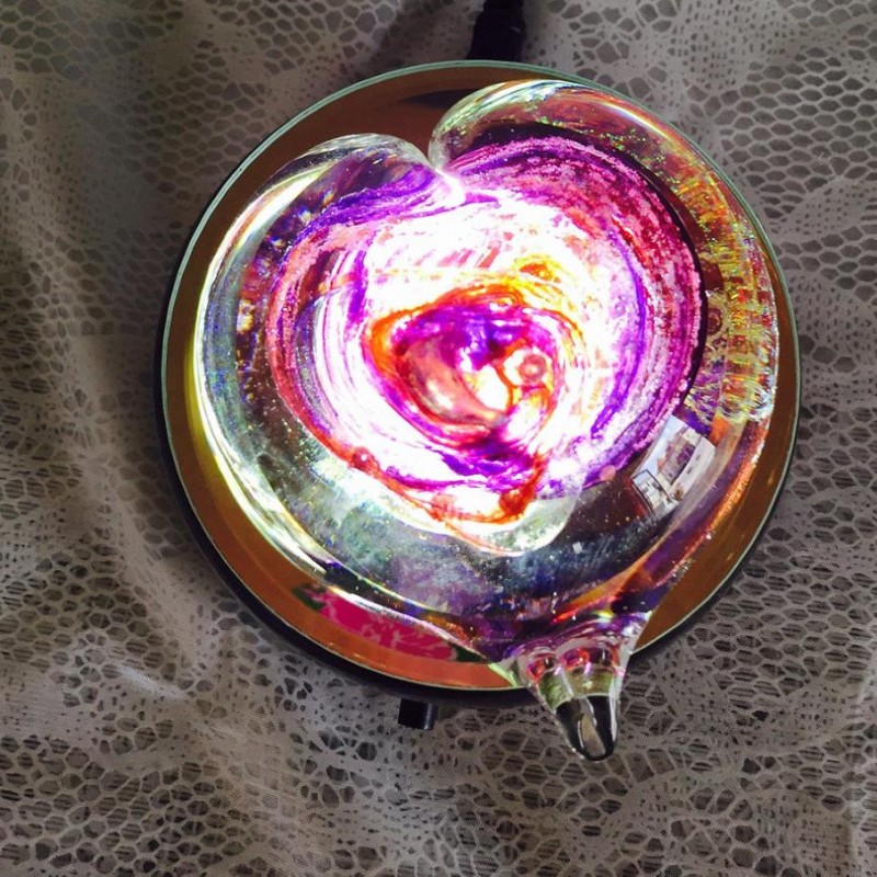 A glass bowl with purple and yellow swirls on it.