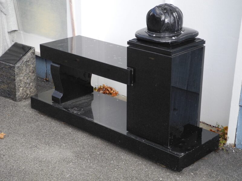 A black bench with a fire hydrant on top of it.