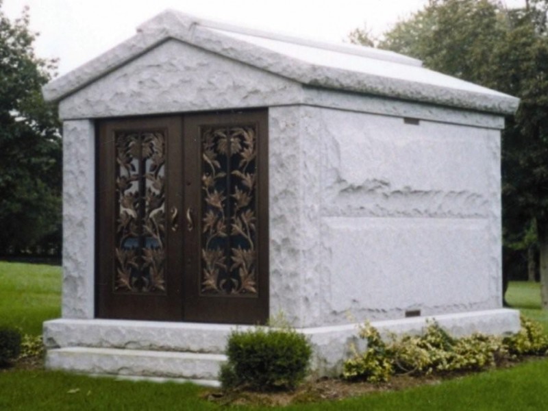 A white grave with two doors and a large roof.