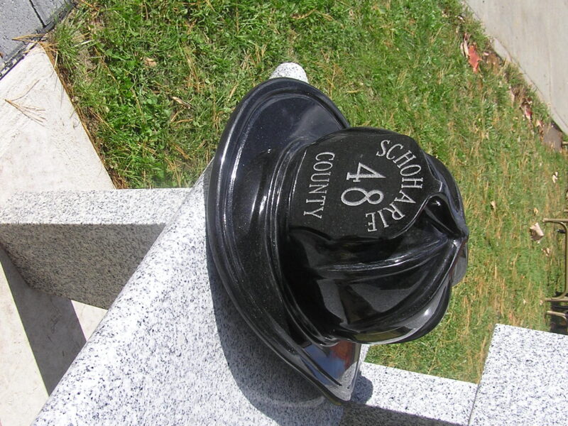 A black fire hat sitting on top of a bench.