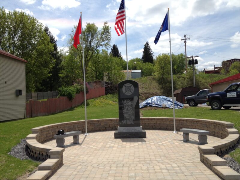 A memorial with flags and benches in the background.